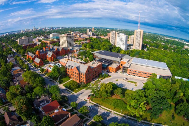 Aerial view of Wisconsin cityscape with historic buildings and green trees surrounded by urban landscape