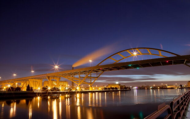 Evening cityscape featuring a bridge and industrial area in Wisconsin