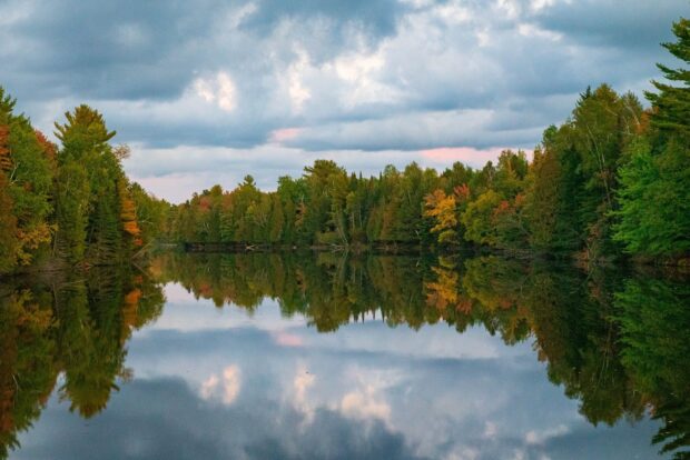 Autumn forest colors reflect on calm lake in Wisconsin forest