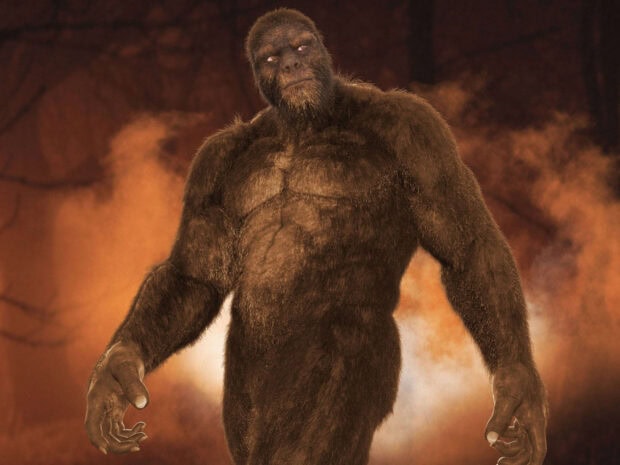A muscular Bigfoot creature standing amidst an orange smoky background