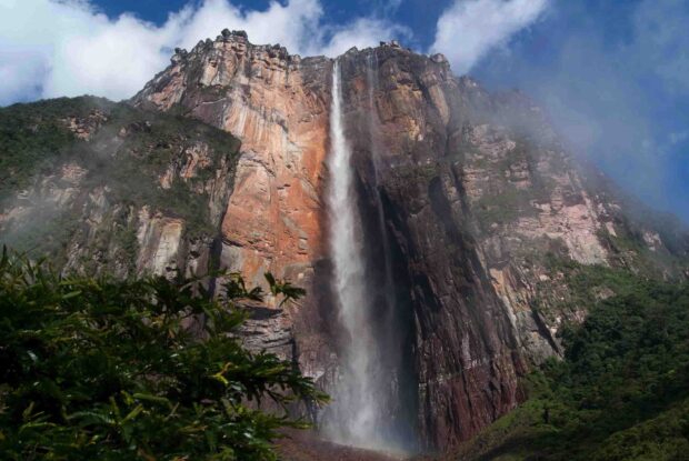 A stunning view of Canaima National Park waterfall surrounded by rocky cliffs and lush greenery
