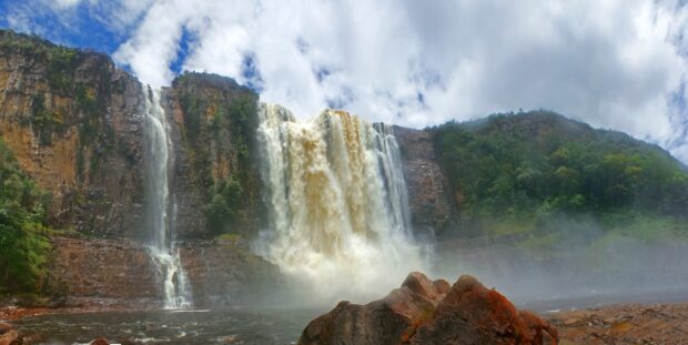 Majestic Canaima National Park waterfall cascading down lush cliffs under a cloudy sky
