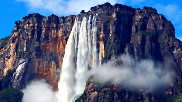 Canaima National Park features a majestic waterfall flowing down a rocky cliff with mist below