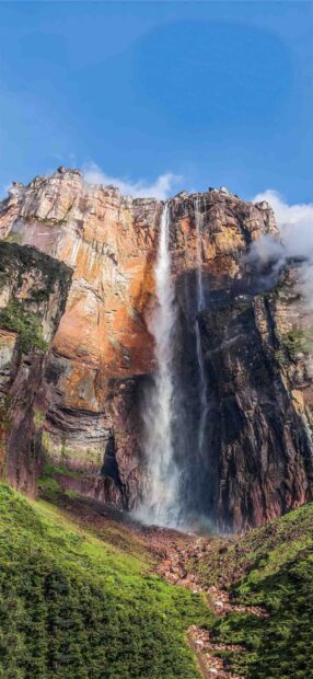 Towering Canaima National Park cliff with a cascading waterfall and lush greenery
