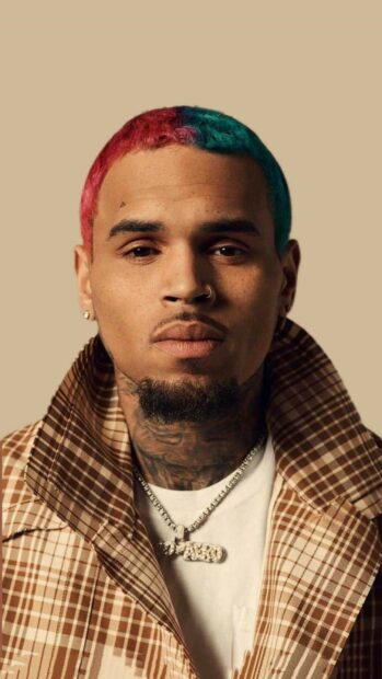 Chris Brown with colorful hair and tattoos looking directly at the camera