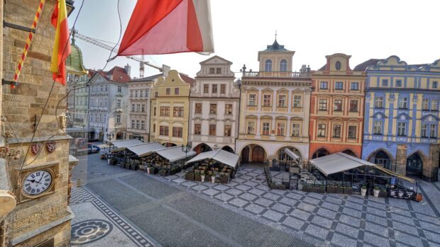 Historic city square with colorful old buildings and outdoor cafes in clear daylight