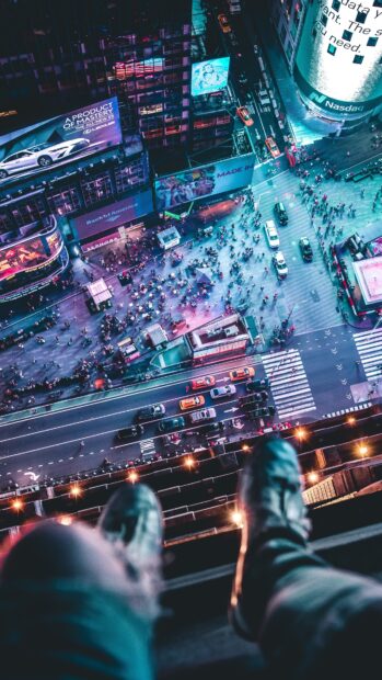 Aerial view of a city square with busy streets and pedestrians at night