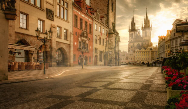 Historic city square with old buildings and church towers at sunset in city square