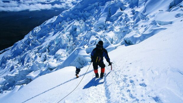 Climbers navigating a snowy mountain ridge during a climbing expedition