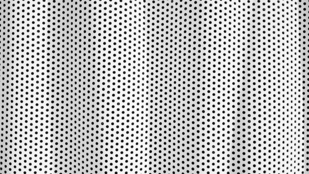 A close up view of a white perforated metal sheet with evenly spaced dots creating a pattern