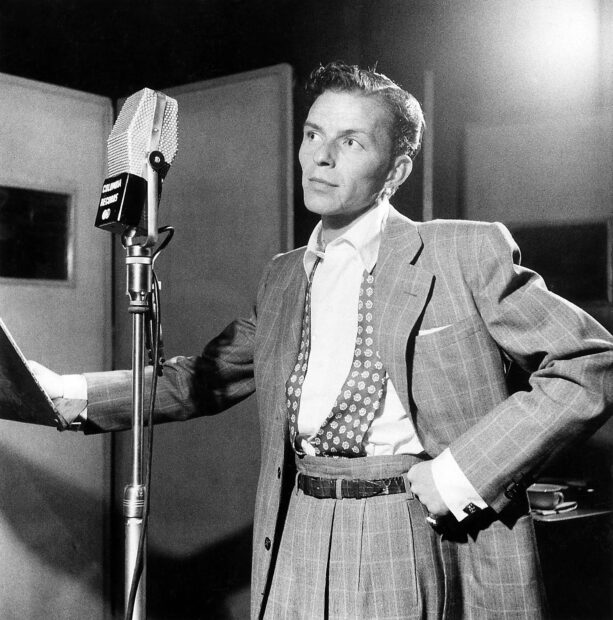 Frank Sinatra in a classic suit recording music in a vintage studio