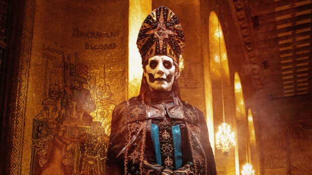 A ghost band performer wearing ornate costume and face paint inside a golden church interior