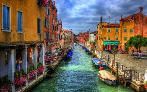 Colorful Venetian canal with gondola boats and vibrant buildings alongside the waterway
