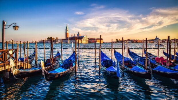 Scenic view of gondola boat docks on the water at sunset