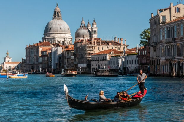 Gondola floating on the canal with historic buildings in Venice cityscape
