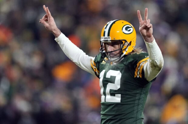 Green Bay Packers player wearing number 12 jersey celebrates on field raising both arms