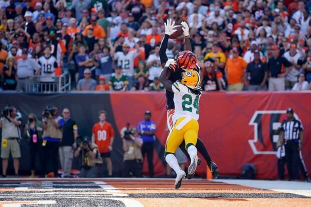 Green Bay Packers player defending a football catch in an intense game