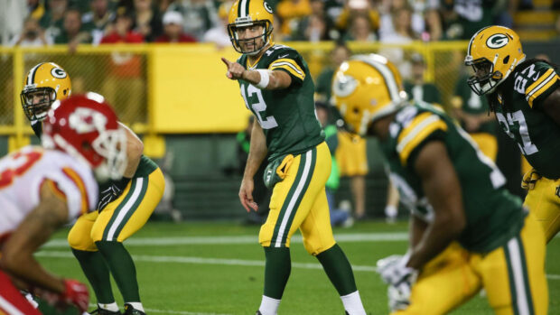 Green Bay Packers quarterback directing team on the field during a game