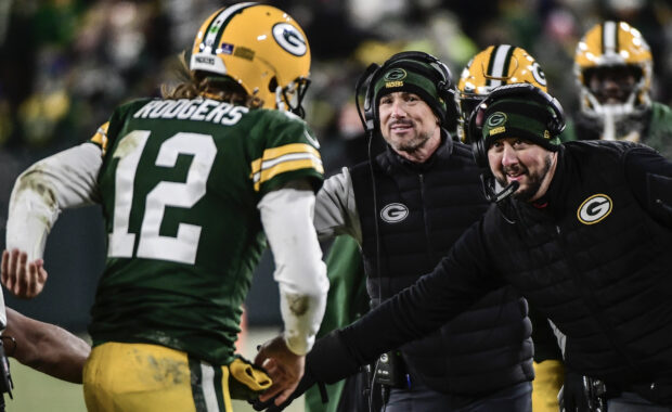 Aaron Rodgers shaking hands with coaches from Green Bay Packers