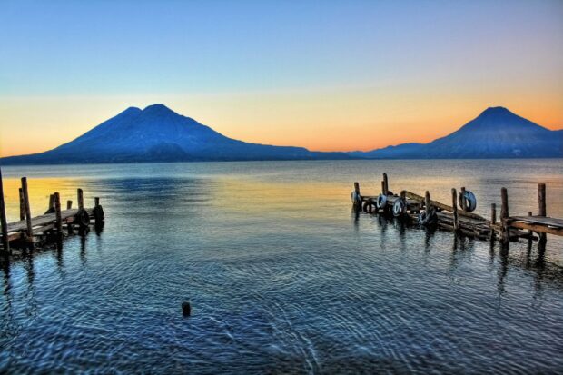 Lake Atitlan with volcanoes under a colorful sunset sky in Guatemala