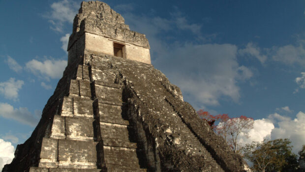 Ancient Mayan temple ruins in Guatemala under a partly cloudy sky