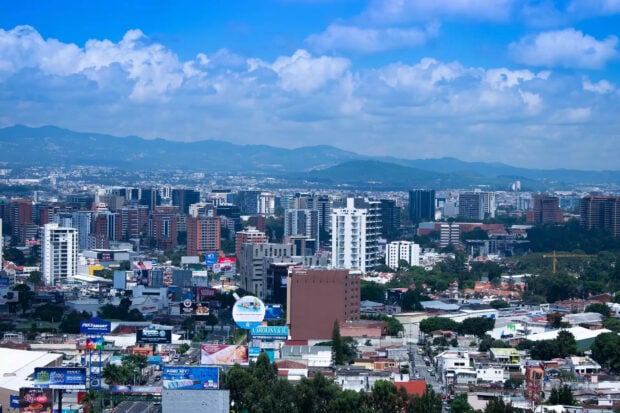 A panoramic view of Guatemala city skyline with mountains in the background