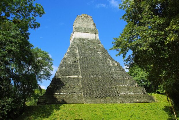 Ancient temple ruin in Guatemala surrounded by lush green forest