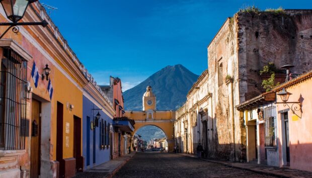 Antigua Guatemala with volcano in the background on a clear blue sky day