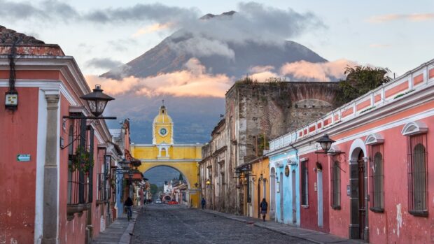 The Antigua Guatemala street view with colorful buildings and volcano in the background