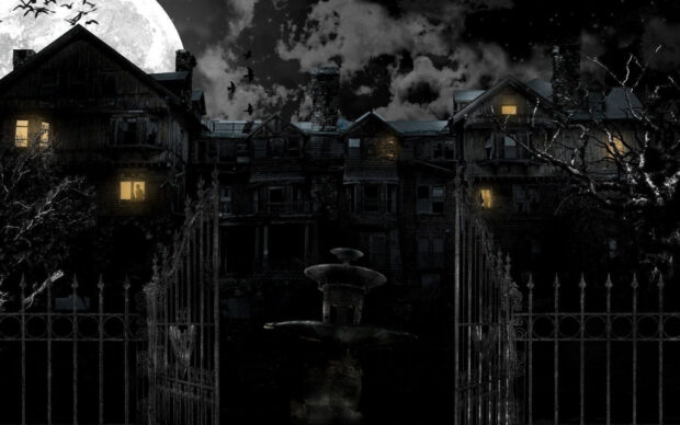 Old haunted house with a full moon and glowing windows at night
