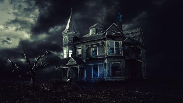 A haunted house surrounded by barren land and a dead tree under a stormy sky