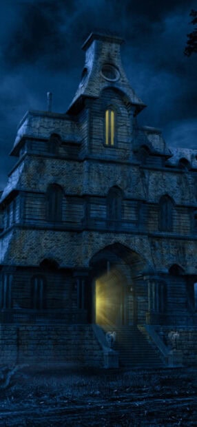 Old haunted house with glowing door at night in dark eerie atmosphere
