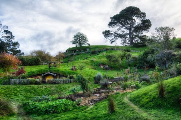 A peaceful hobbiton scene with green hills and cozy homes nestled in the landscape