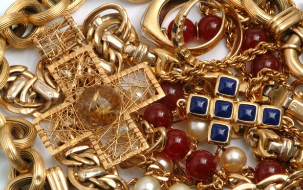 A collection of gold jewels featuring intricate chains and red and blue gemstone accents