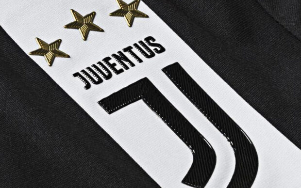 Close up of Juventus logo on a black and white fabric with gold stars