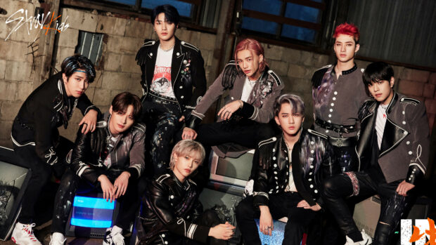 Stray Kids members posing in dark outfits depicting K Pop style and attitude