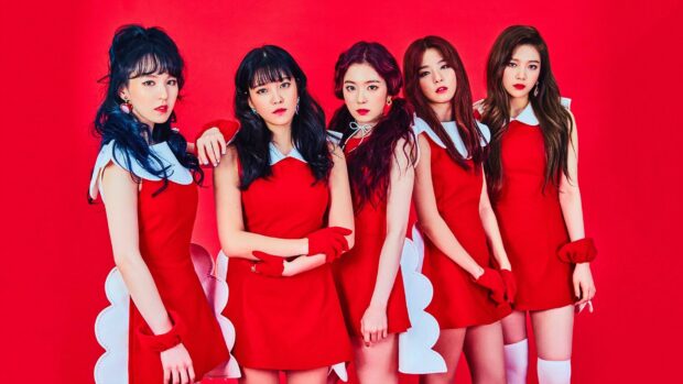 Five K pop idols posing in red dresses and gloves against a red background