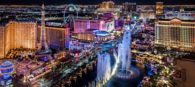 A vibrant Las Vegas Strip cityscape with famous landmarks and fountain shows at night