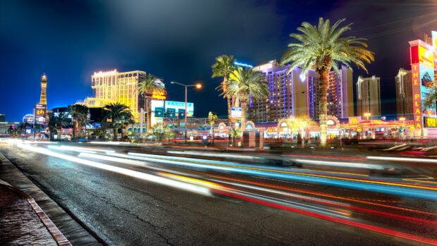 Night view of Las Vegas Strip with palm trees and bright city lights