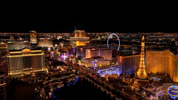 A nighttime view of the Las Vegas Strip cityscape with bright lights and iconic buildings