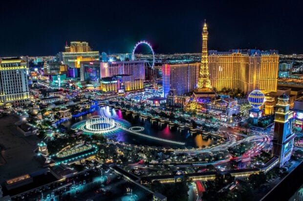 A vibrant night view of Las Vegas Strip skyline with illuminated buildings and the famous Eiffel Tower replica