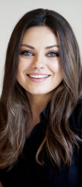 Close up of Mila Kunis smiling with long hair and green eyes