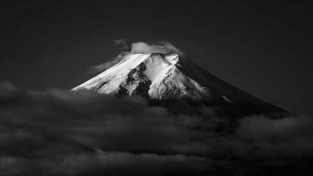 Snow capped Mount Fuji Japan standing above clouds at dusk