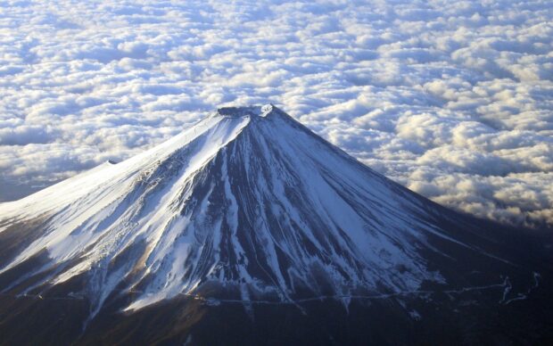 Snow covered Mount Fuji Japan with clouds in the background