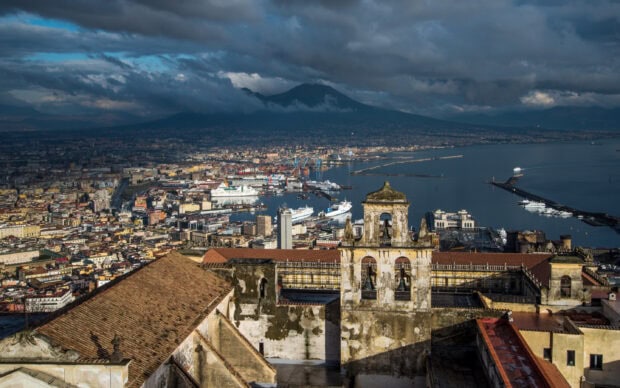 Ancient bell tower overlooking the Naples cityscape with Mount Vesuvius in the background