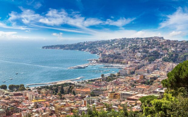 A panoramic view of Naples cityscape with coastal hills and a vibrant urban area