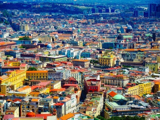 Colorful cityscape of Naples with historic buildings and domes under a bright sky
