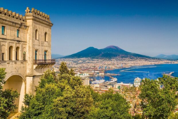Historic architecture and lush greenery overlooking Naples city and volcano
