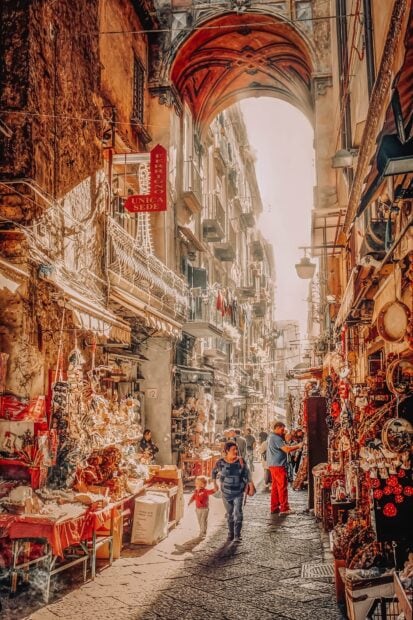 Narrow street market with Naples cityscape and local people walking