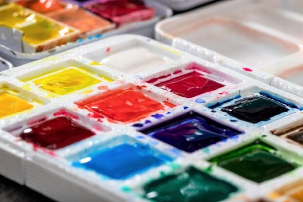 A close up of vibrant paint colors in a palette for artistic use